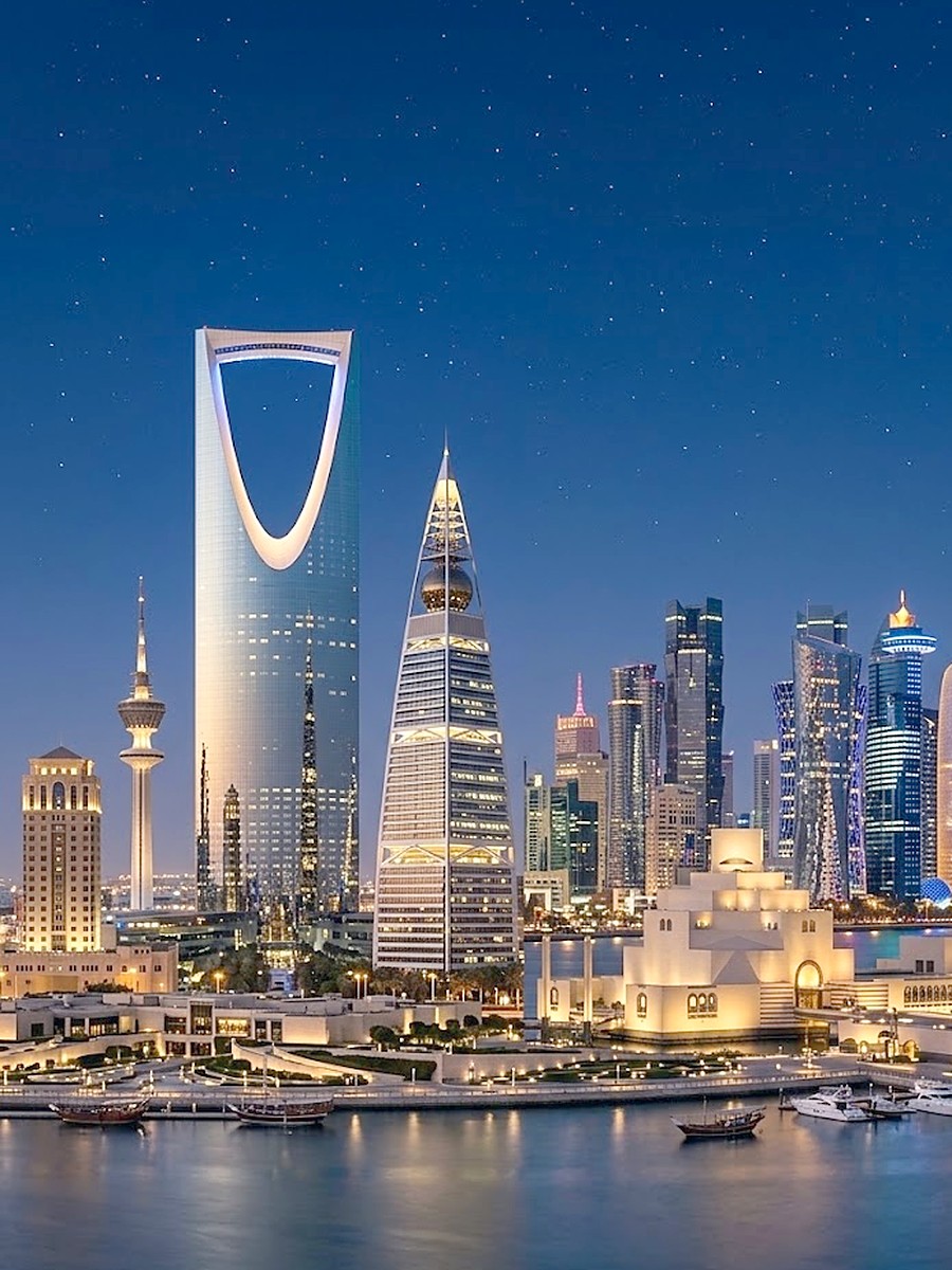 Riyadh and Doha landmarks across a Gulf waterfront at night